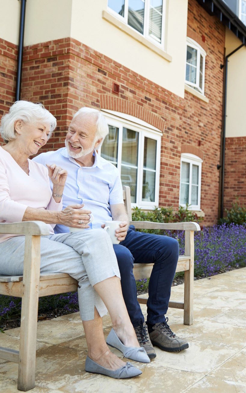 Caregiver assisting elderly couple with coloring